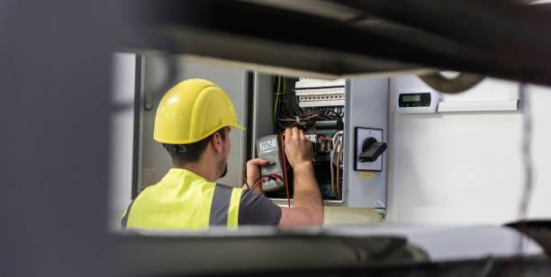 Experienced electrician testing panel components and circuit loads with diagnostic equipment